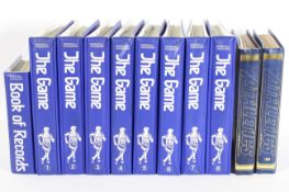 A collection of 'The game' in eight blue binder folders,