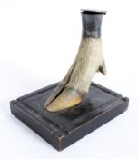 A stag hoof inkwell with silver coloured hinged top, circa 1900, on ebonised plinth base,