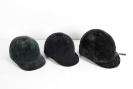 Three assorted black velvet riding hats, including: Castle Brand (6 7/8 /56),