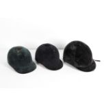 Three assorted black velvet riding hats, including: Castle Brand (6 7/8 /56),