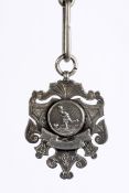 A silver football medal and large silver link chain, the medal of escutcheon shape,