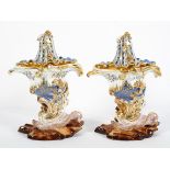 A pair of Jacob Petit blue ground cornucopia pot pourri vases with pierced covers, on rocky bases,