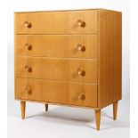 A Meredew 1960's golden oak straight four chest of drawers having shaped knob handles