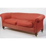 A 19th century Chesterfield two seat sofa, upholstered in red, with two drop-in cushions,