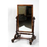 A Victorian mahogany cheval mirror, the rectangular plate on scrolling supports, 132cm high,