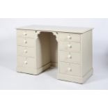 A painted twin pedestal desk or dressing table, with two runs of four graduated drawers,