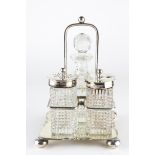 An Edwardian silver cruet on stand, comprising two silver topped glass pots and a glass bottle,