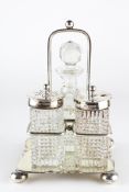 An Edwardian silver cruet on stand, comprising two silver topped glass pots and a glass bottle,