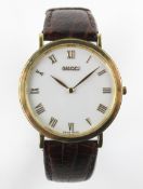 A Gucci cased gentleman's wristwatch, with brown leather strap, white dial with gilt metal case,