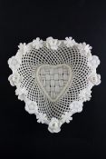 A Belleek heart shaped basket, four strand base, applied with flowers to the rim,