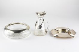 A silver ashtray and a silver mounted glass example,