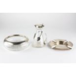 A silver ashtray and a silver mounted glass example,