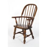 A Child's elm Windsor chair, on turned baluster splayed legs,