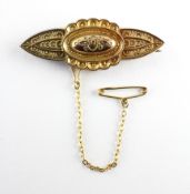 A yellow metal bar brooch with beaded filigree design.