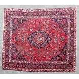 An East Persian village carpet, the red ground with angular vines,with a central blue medallion,
