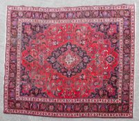 An East Persian village carpet, the red ground with angular vines,with a central blue medallion,