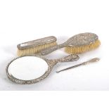 A silver and white metal backed brush set,