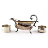 A mid century silver sauce boat raised upon three hoof feet, with ribbed border,