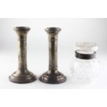 A pair of silver candlesticks, hallmarks rubbed, together with a silver mounted cut glass jar,