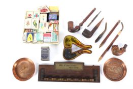 A collection of smoking paraphernalia, including two copper advertising trays for Daimler,