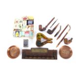 A collection of smoking paraphernalia, including two copper advertising trays for Daimler,