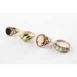 A collection of four rings to include an onyx signet ring, A cameo ring,