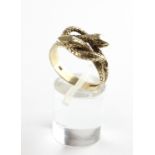 A yellow metal ring in the design of interlocking snakes. Hallmarked 9ct gold. Size R