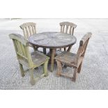 A cartwheel table and four chairs with slatted backs, the table 105 cm diameter x 74 cm high,