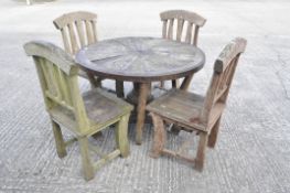 A cartwheel table and four chairs with slatted backs, the table 105 cm diameter x 74 cm high,