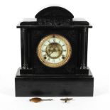 A Victorian black slate mantel clock, the ivorine dial with a central exposed escapement,