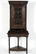 An Edwardian stained oak corner unit and a glazed corner display cabinet,