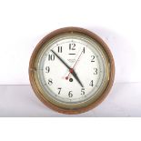 A Smiths Astral brass bulk head clock, the 7 1/2" dial on a brass body and wooden wall mount,