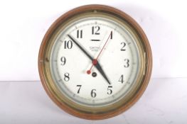 A Smiths Astral brass bulk head clock, the 7 1/2" dial on a brass body and wooden wall mount,