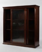 An Edwardian mahogany glazed bookcase with sliding double doors enclosing four adjustable shelves,