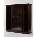 An Edwardian mahogany glazed bookcase with sliding double doors enclosing four adjustable shelves,