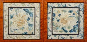 A pair of Chinese silk panels, circa 1900, worked with flowers inside a floral sprig border,