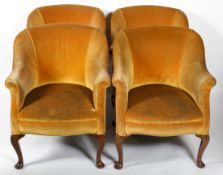 A set of four Edwardian tub chairs upholstered in ochre velvet, on mahogany scroll cabriole legs,