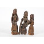 Three Eastern carved wooden figures, possibly Chinese, including one holding a young child,