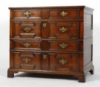 A 17th century oak two-section chest of drawers, with geometric panelled front,