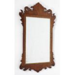 A George II style walnut wall mirror with foliate cresting, with cushion shaped parcel-gilt frame,