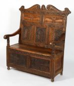 An oak hall bench, the scrolling toprail above carved panels with beasts and arched panels,