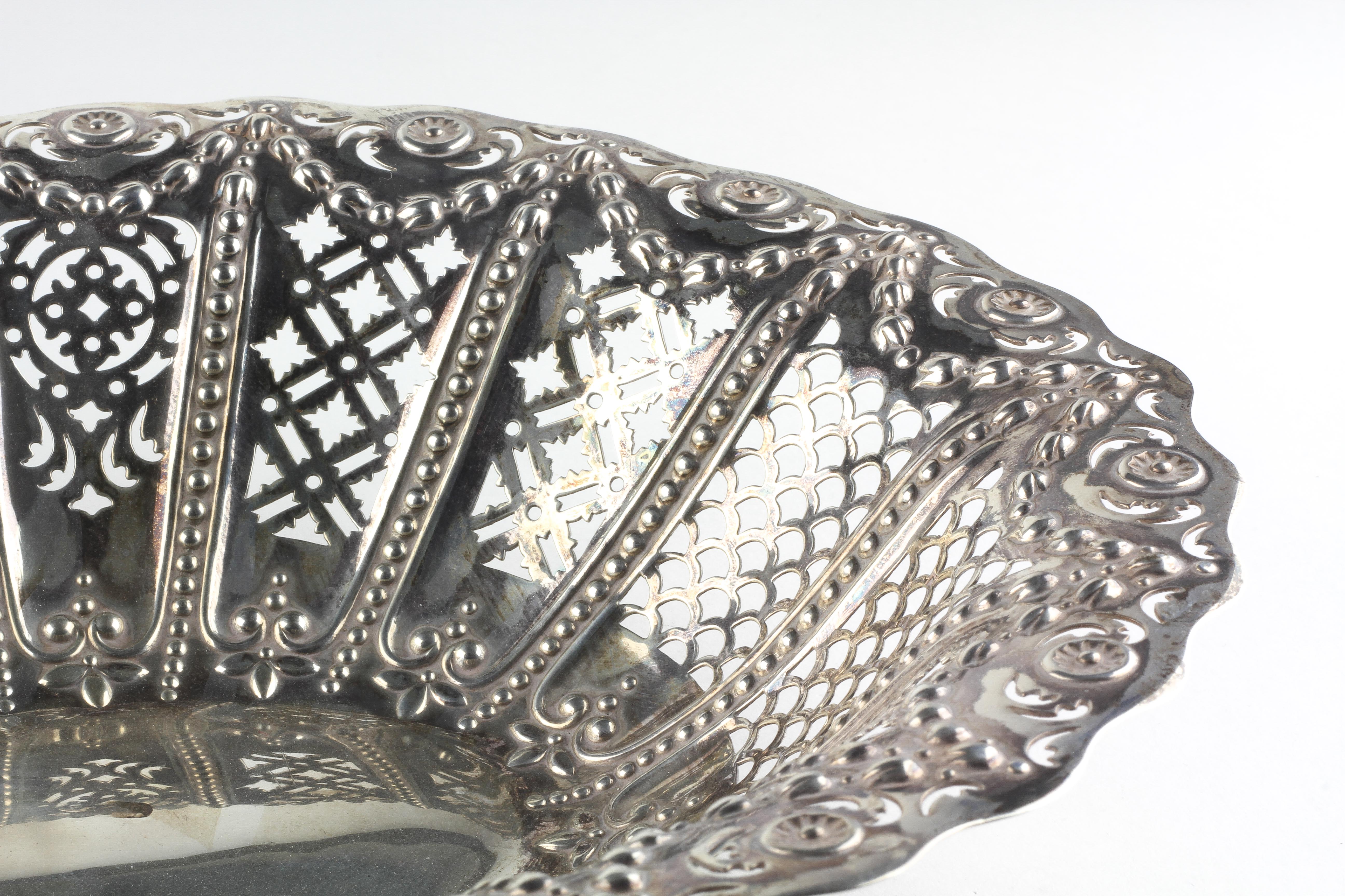 A late Victorian silver basket of oval form, decorated throughout with pierced and embossed motifs, - Image 2 of 3