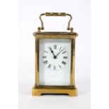 A French brass carriage time piece, with an enamelled dial and eight day movement,