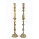 A large pair of brass candlesticks, each with knopped stems, on domed foot, with fixed sconce,