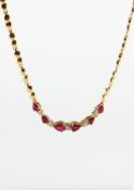 A yellow metal centrepiece necklace having heart shaped links and set with rubies and diamonds.