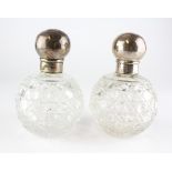 A pair of silver topped cut-glass scent bottles, hallmarked London, 1890,