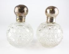 A pair of silver topped cut-glass scent bottles, hallmarked London, 1890,