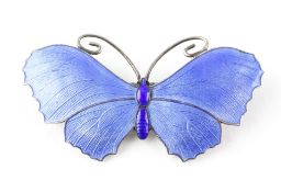 An early 20th century silver brooch in the form of a butterfly, inlaid with blue enamel,