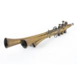 A vintage French brass hunting horn, with four conjoined horns and three valves,