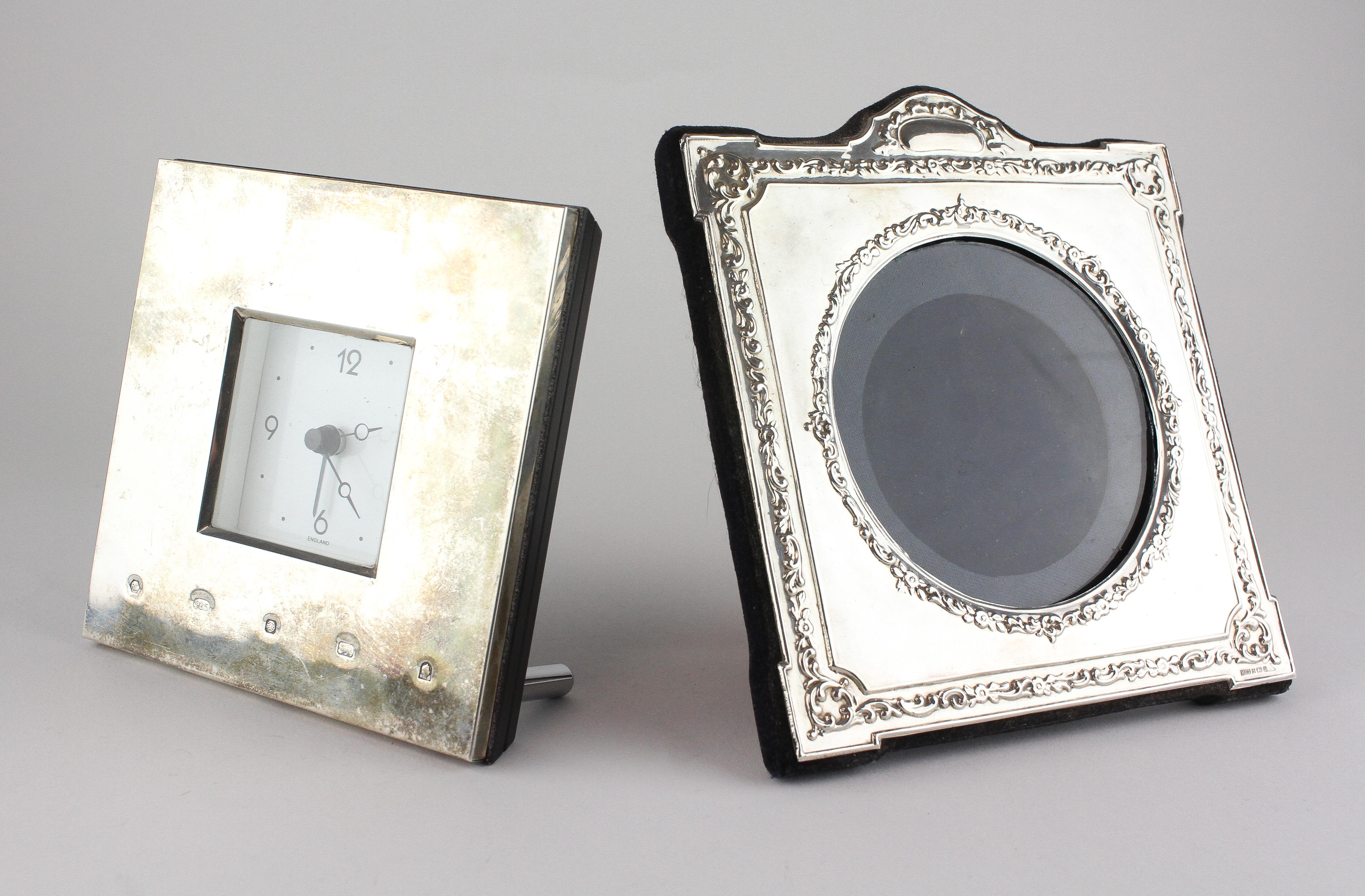 A modern silver photo frame of square form with embossed floral decoration,